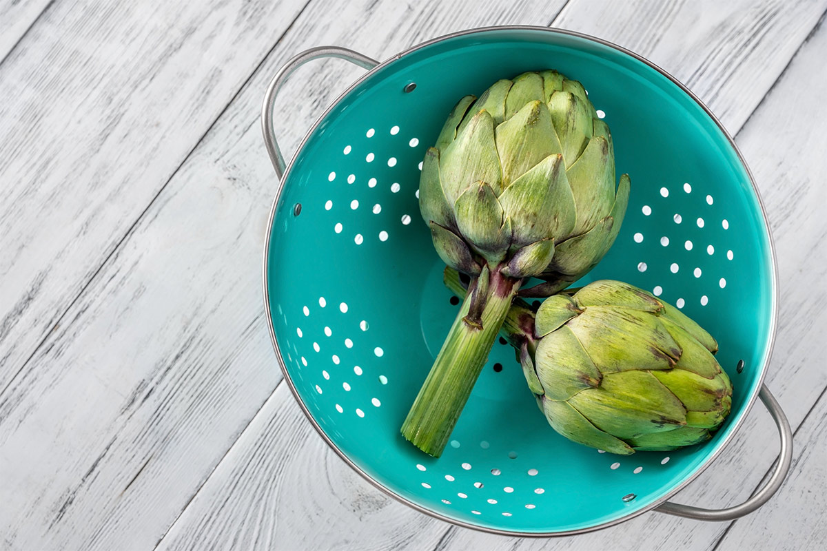 Artichoke hearts are in a green colander | Girl Meets Food