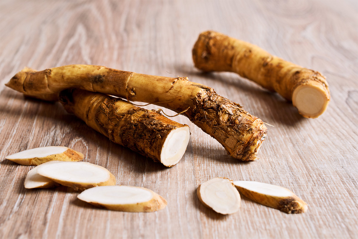 A few pieces and slices of horseradish on the wooden surface  | Girl Meets Food