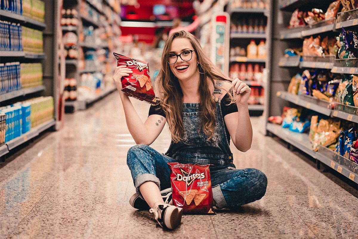 Woman is sitting on the floor and holding Doritos package | Girl Meets Food
