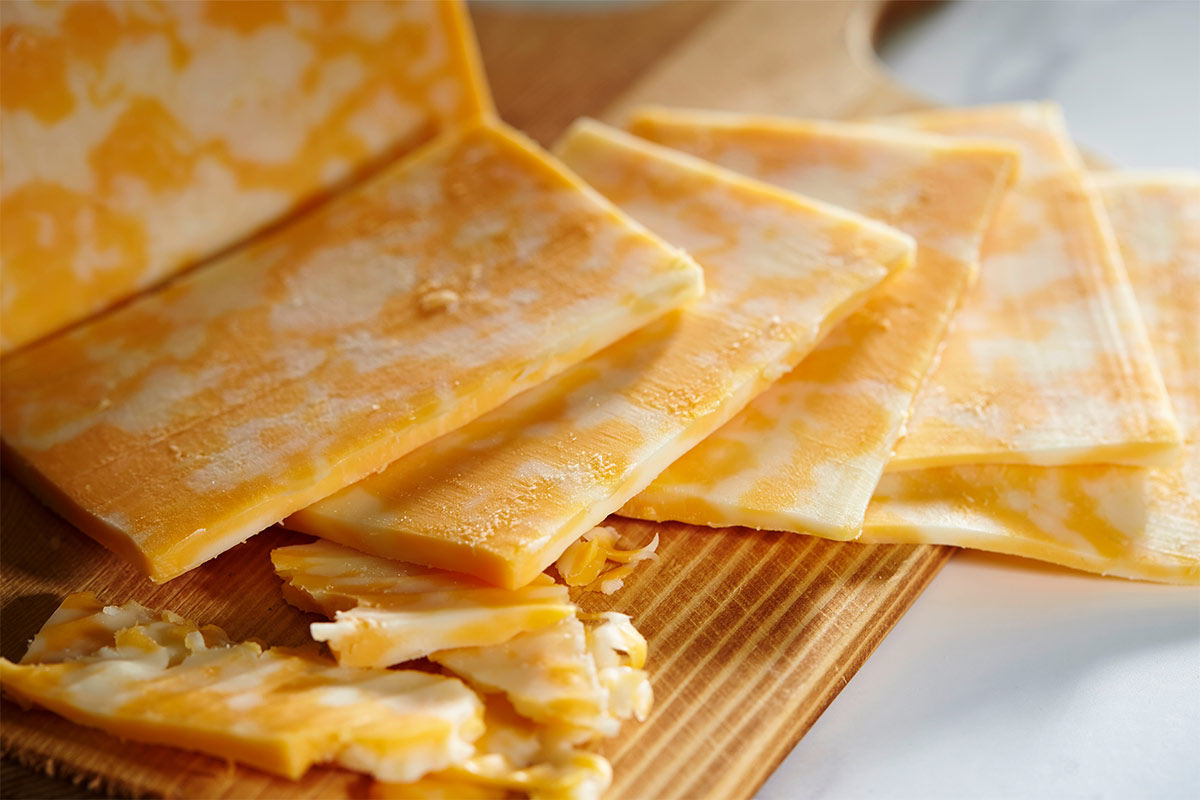 Colby cheese slices lie on a cutting board | Girl Meets Food