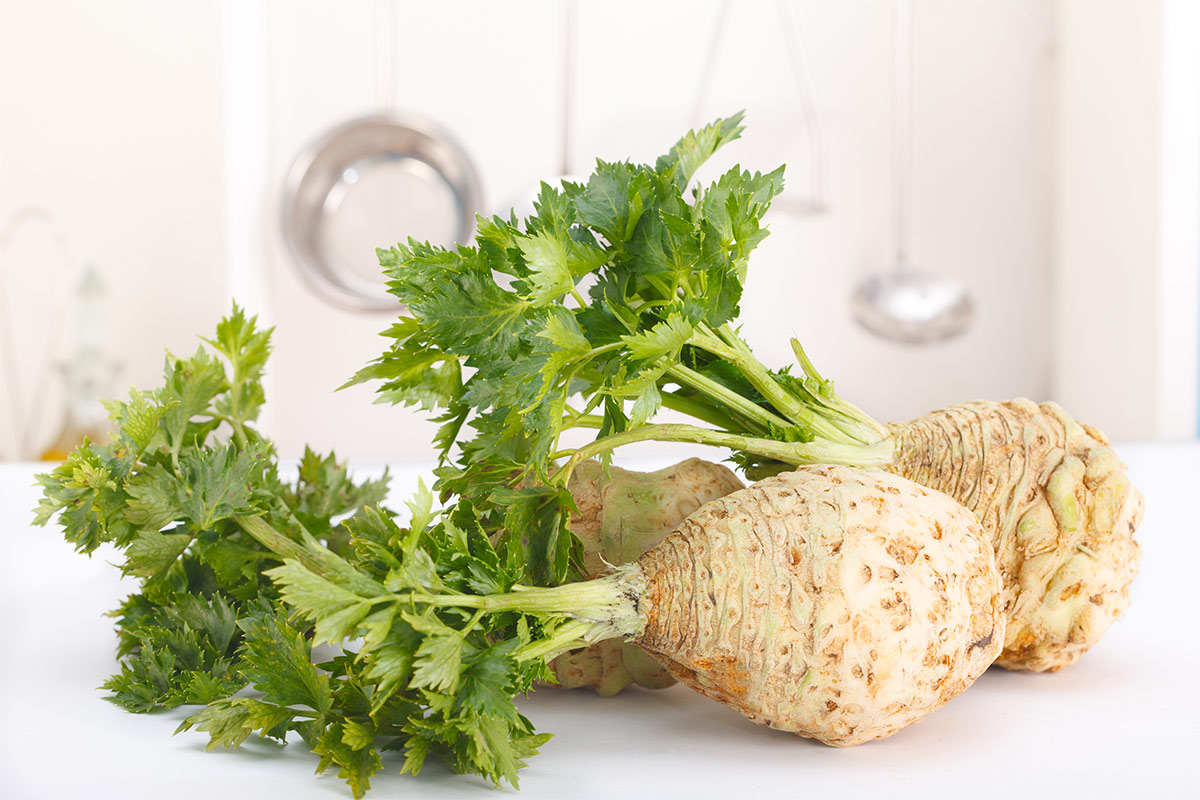 A few fresh celery on a white surface | Girl Meets Food