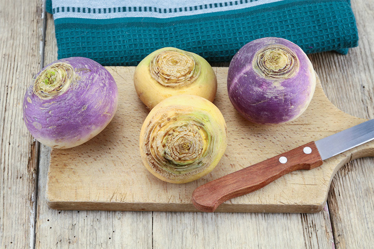 Four turnips and a knife lie on a cutting board | Girl Meets Food