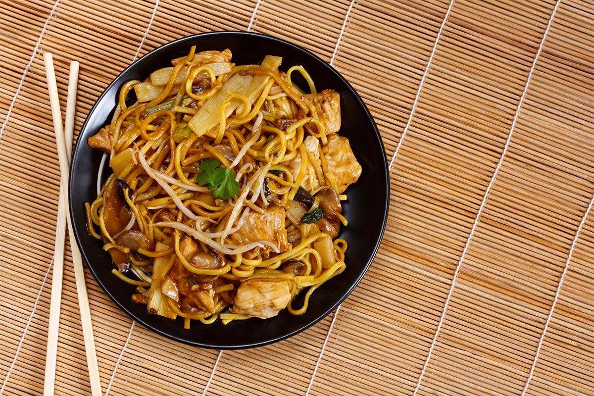 A black plate of Chow Mein and chopsticks | Girl Meets Food