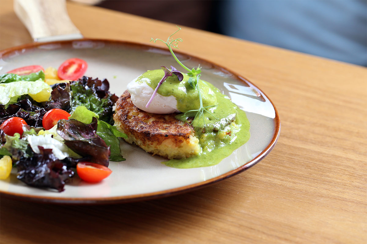 A plate of hash brown with green salad is on the table | Girl Meets Food