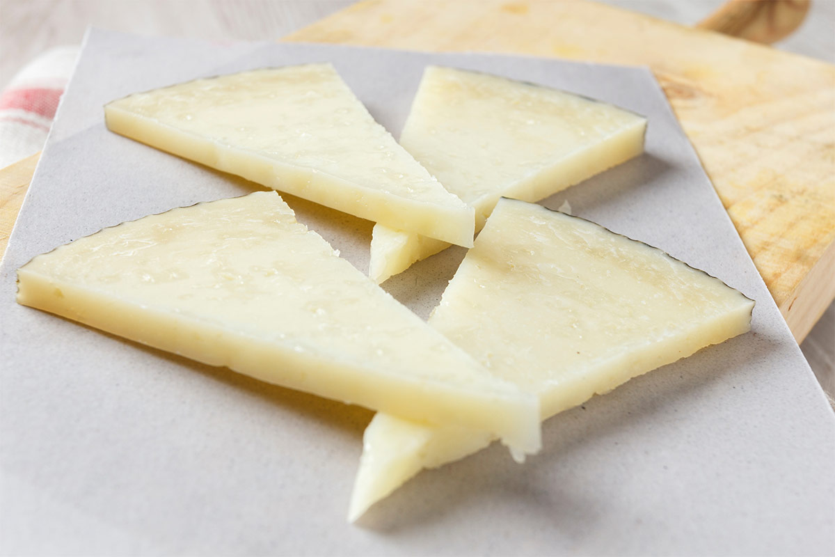 Four Manchego cheese slices on grey surface | Girl Meets Food