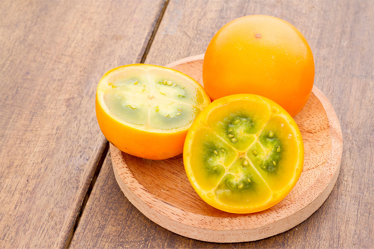 Naranjilla fruit on a wooden plate | Girl Meets Food