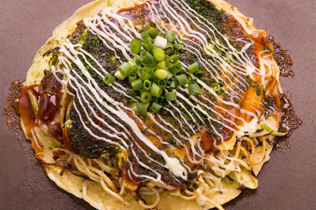Okonomiyaki on a brown surface | Girl Meets Food