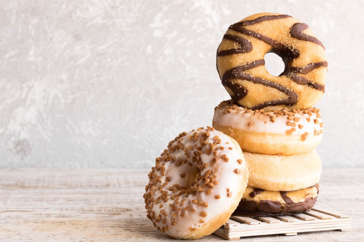 A stack of donuts is on a wooden board that is on a wooden surface | Girl Meets Food