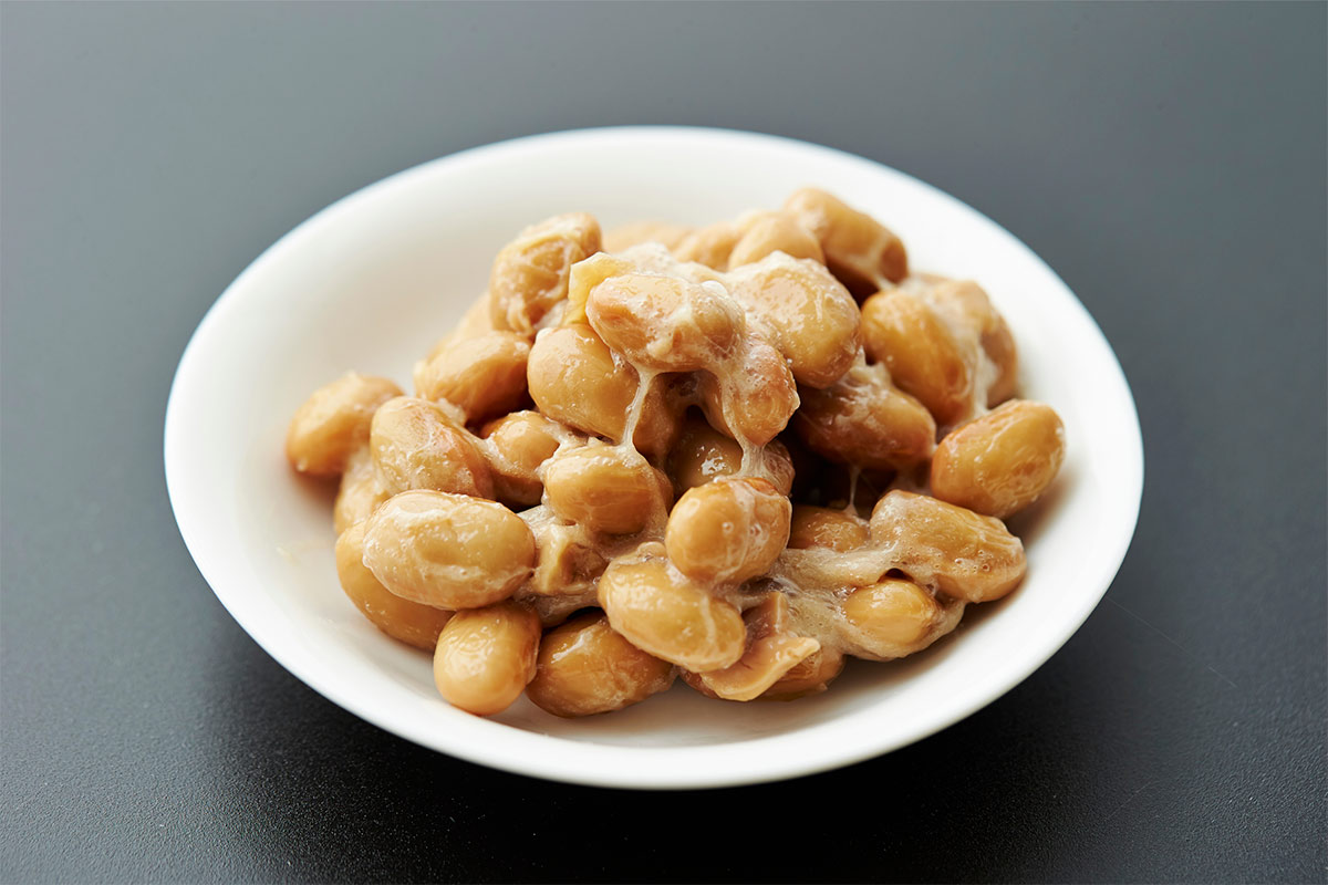 A small bowl with natto is on a grey surface | Girl Meets Food