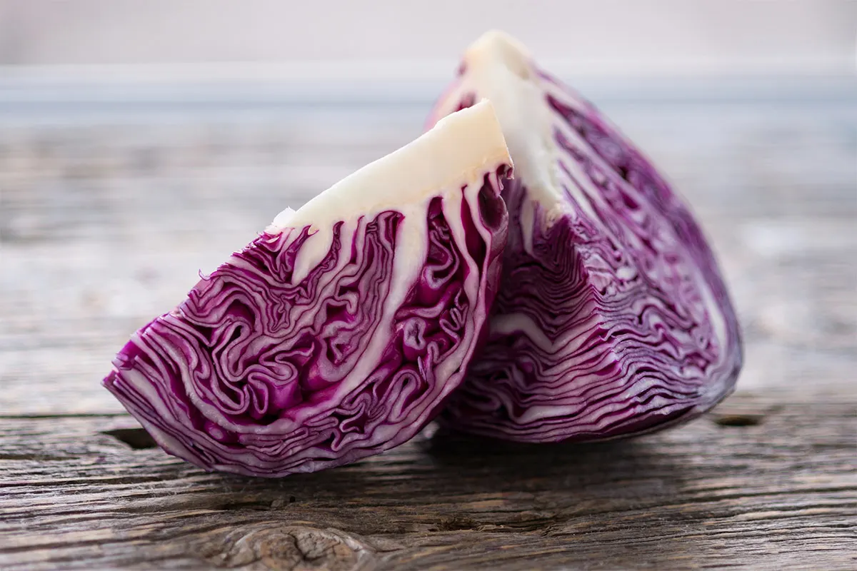 Two wedges of red cabbage on a wooden surface | Girl Meets Food