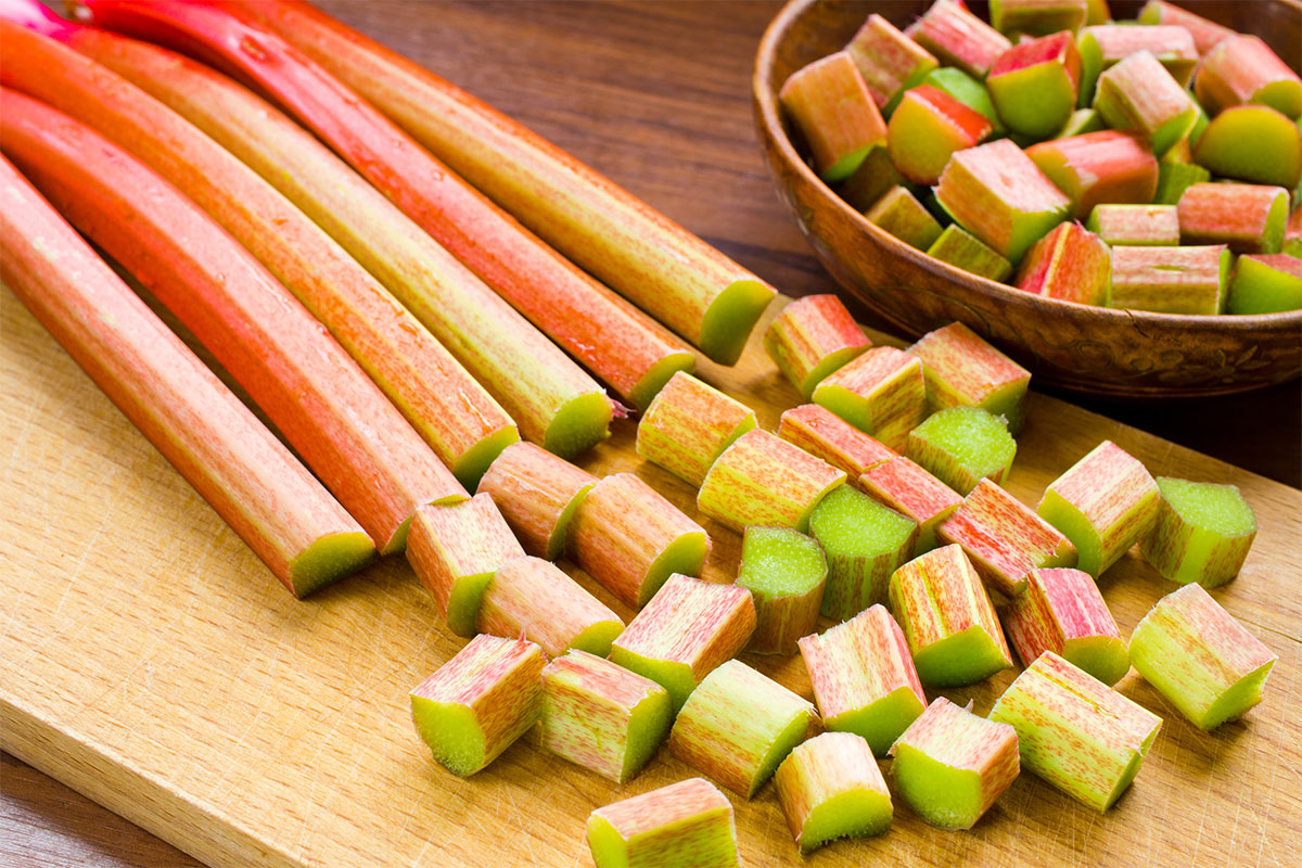 Rhubarb stems are chopped in cubes on a cutting board | Girl Meets Food