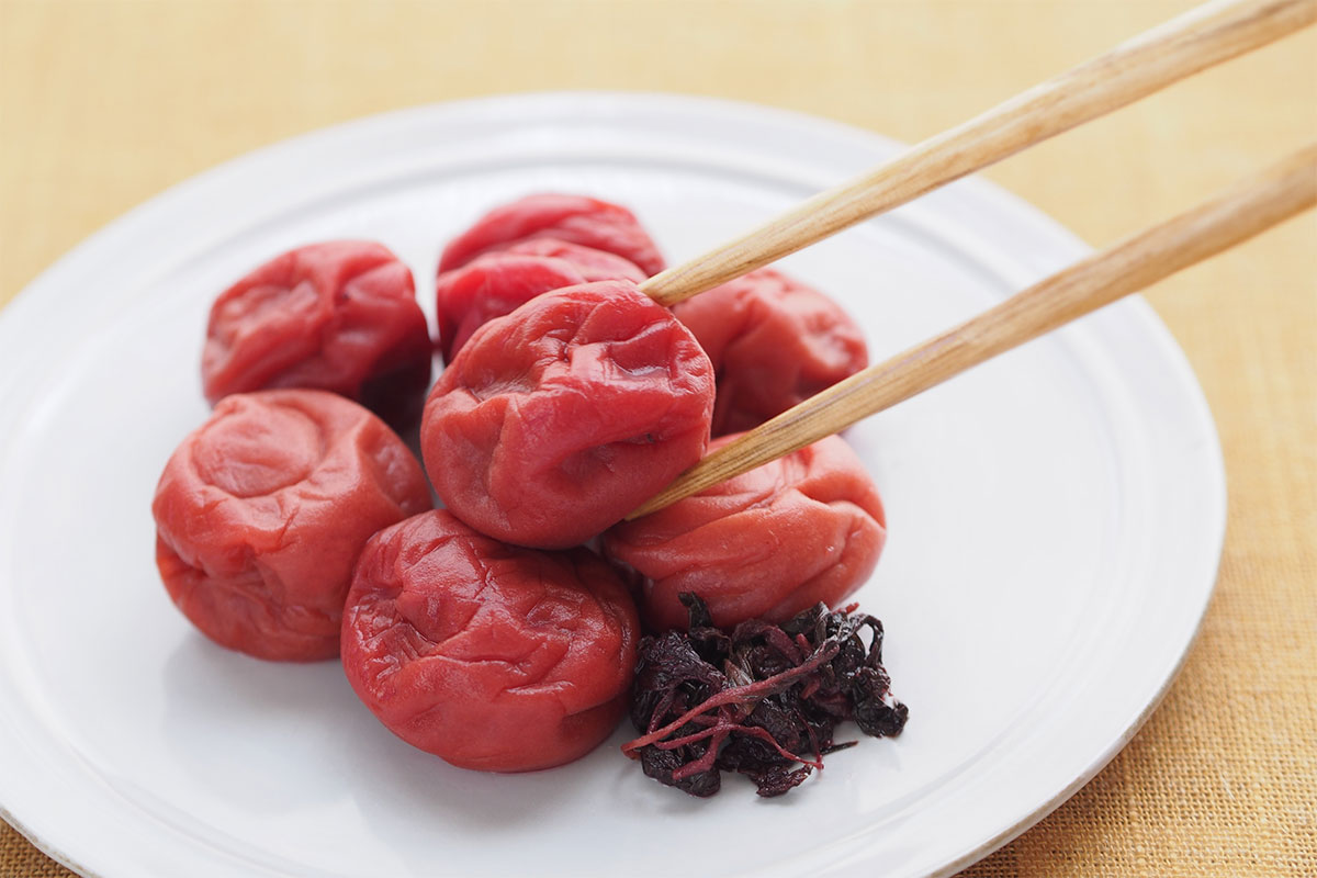 Someone is taking umeboshi from a plate using sticks | Girl Meets Food