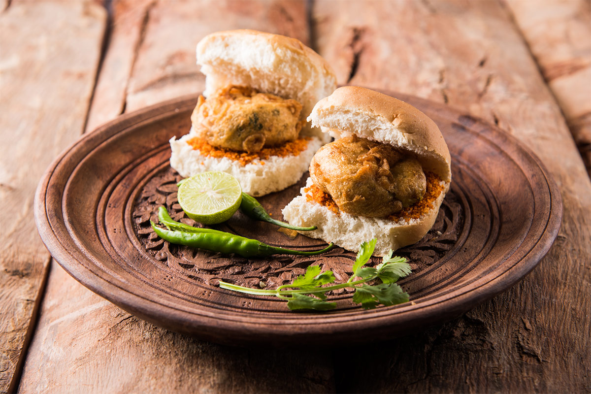 Vada pav snack on a wooden plate | Girl Meets Food