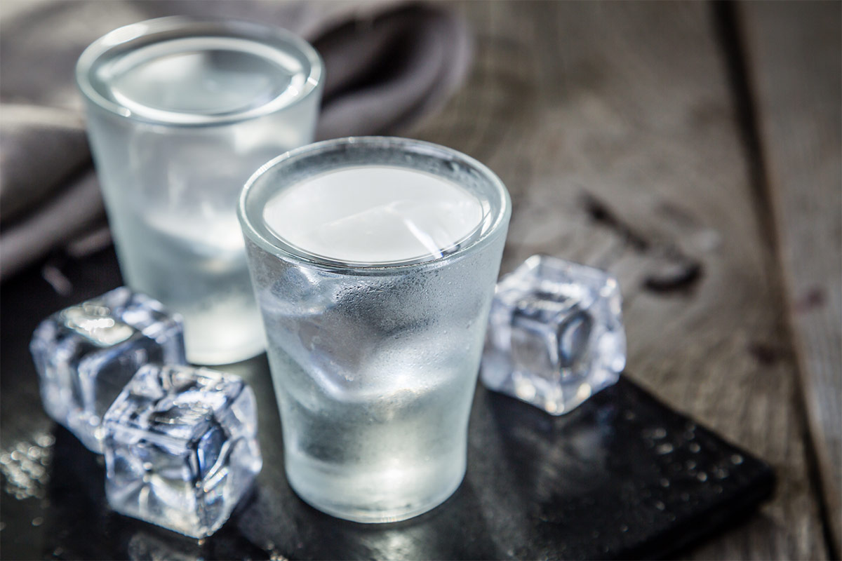 Two glasses of vodka with ice cubes on wooden surface | Girl Meets Food