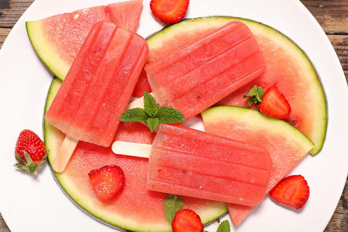 Watermelon popsicles, watermelon slices and strawberry slices on a plate | Girl Meets Food