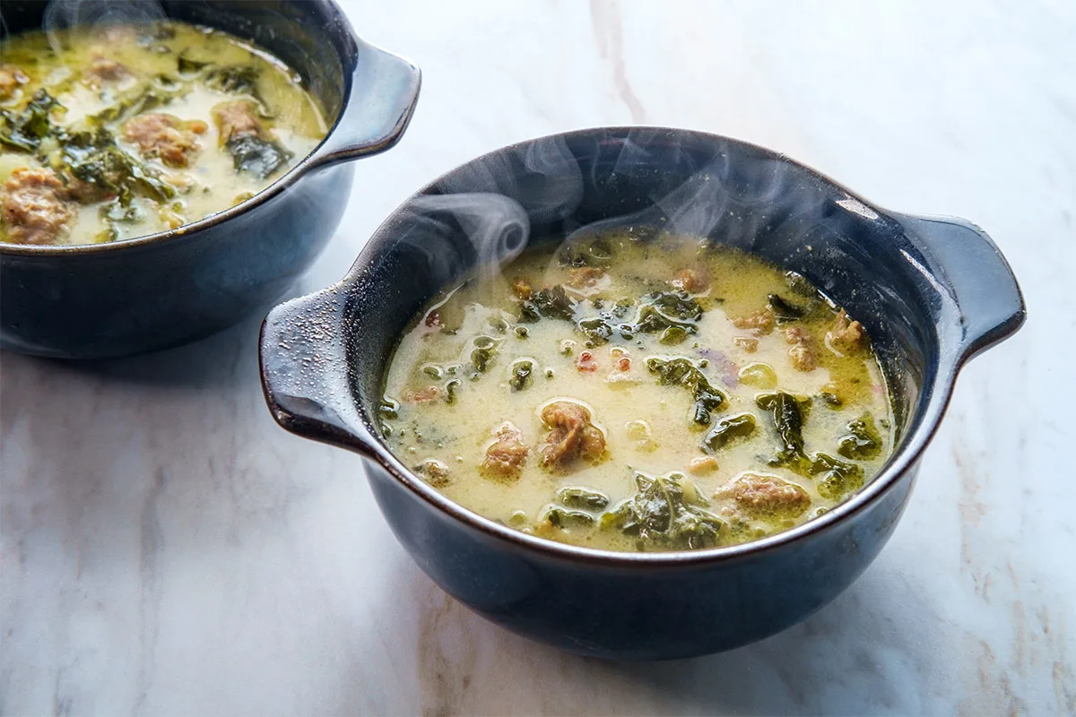 Two black bowls of Zuppa Toscana on marble surface | Girl Meets Food