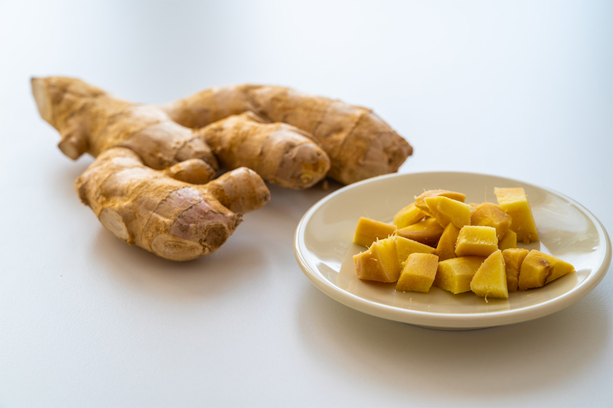 Cut ginger on a plate. There are a few roots next to it | Girl Meets Food