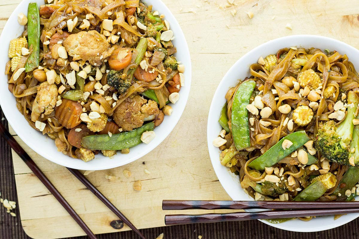 Two plates of vegan peanut sauce stir fry with noodles | Girl Meets Food