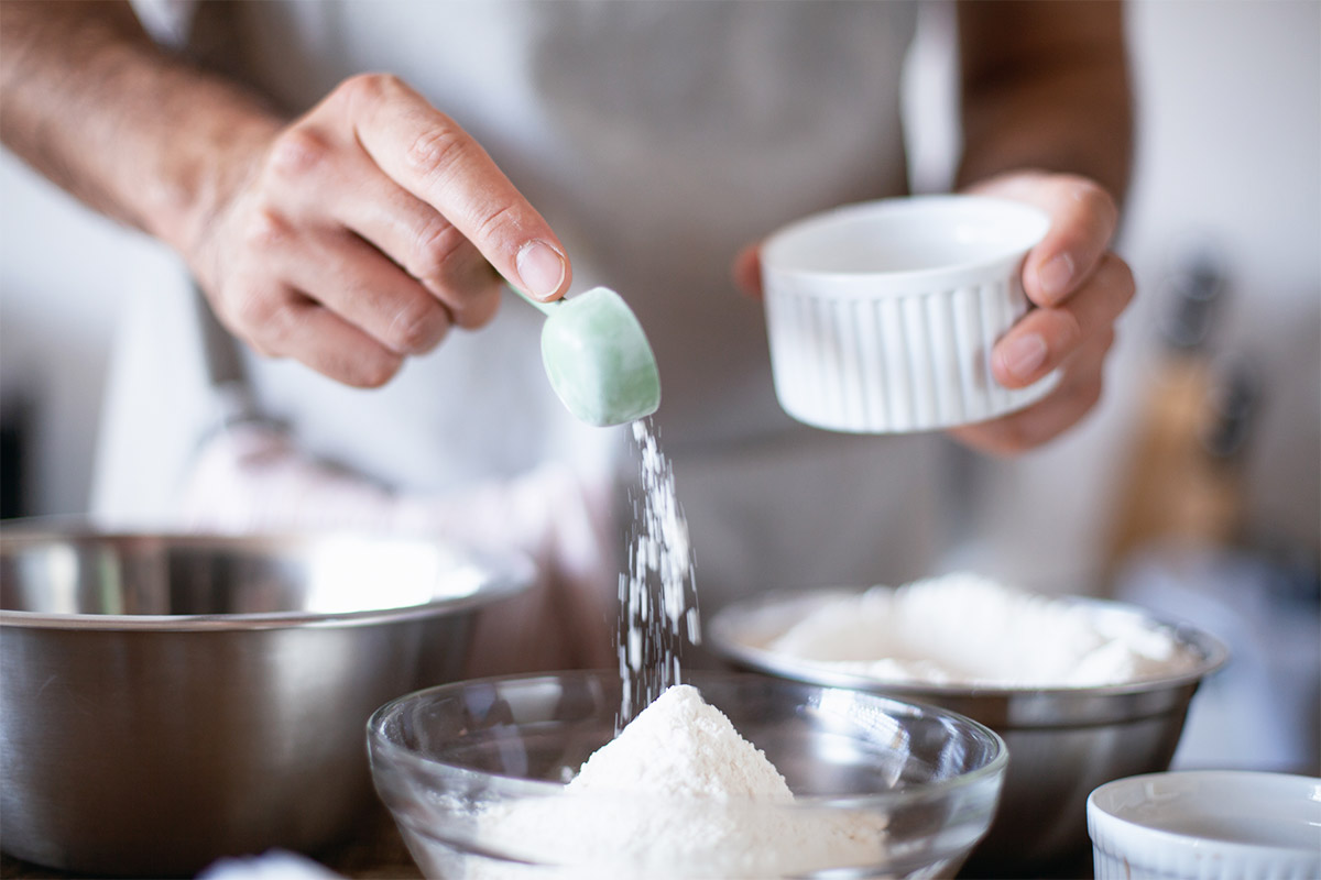 Person is measuring flour with a spoon | Girl Meets Food