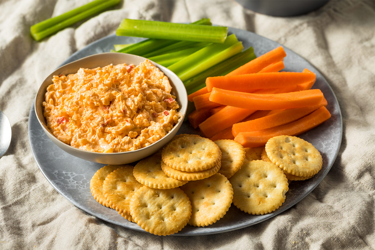 A bowl of pimento cheese is served with crackers and veggies | Girl Meets Food