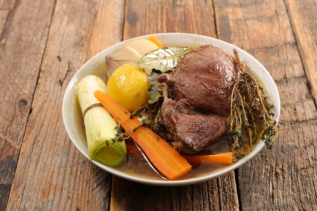 A bowl of Pot-au-Feu on wooden surface | Girl Meets Food