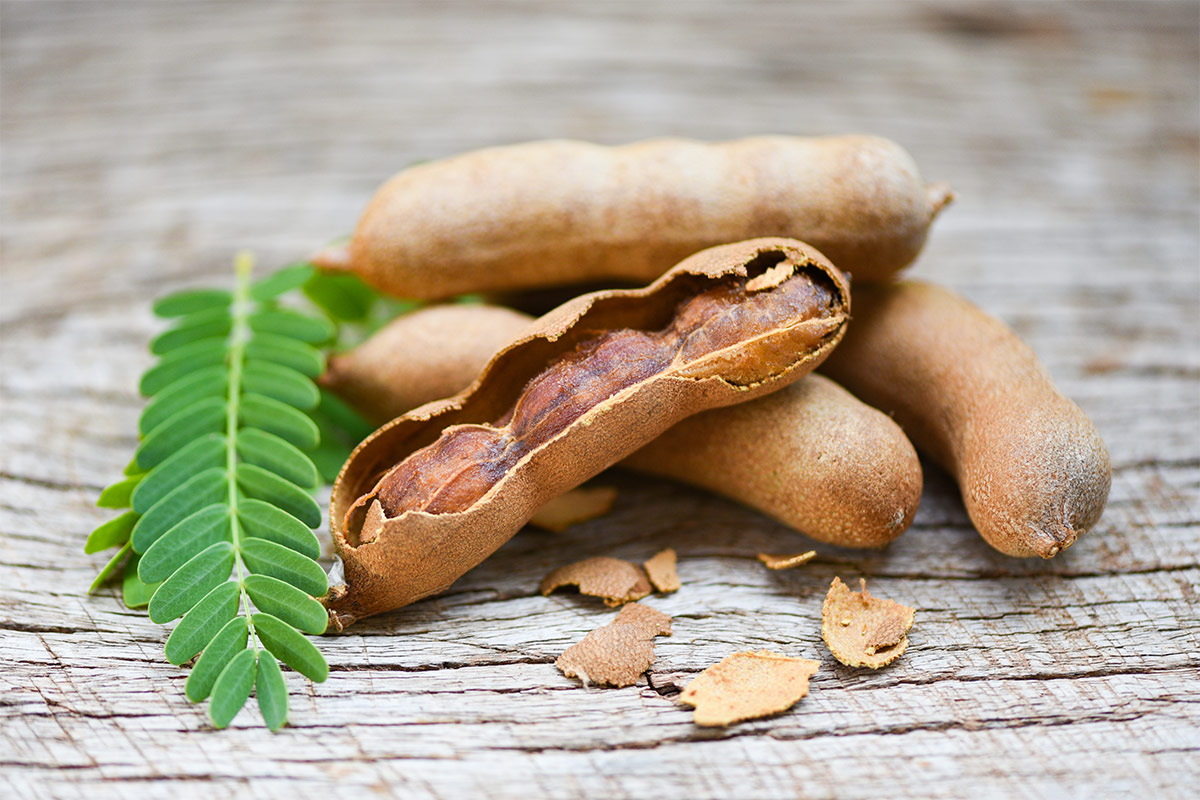 Tamarind beans on wooden surface | Girl Meets Food