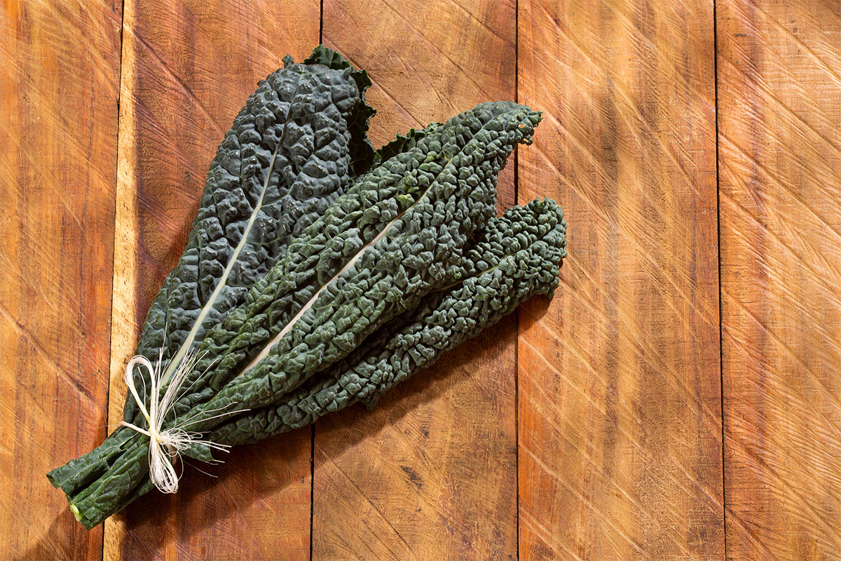 Tuscan kale leaves on wooden surface | Girl Meets Food