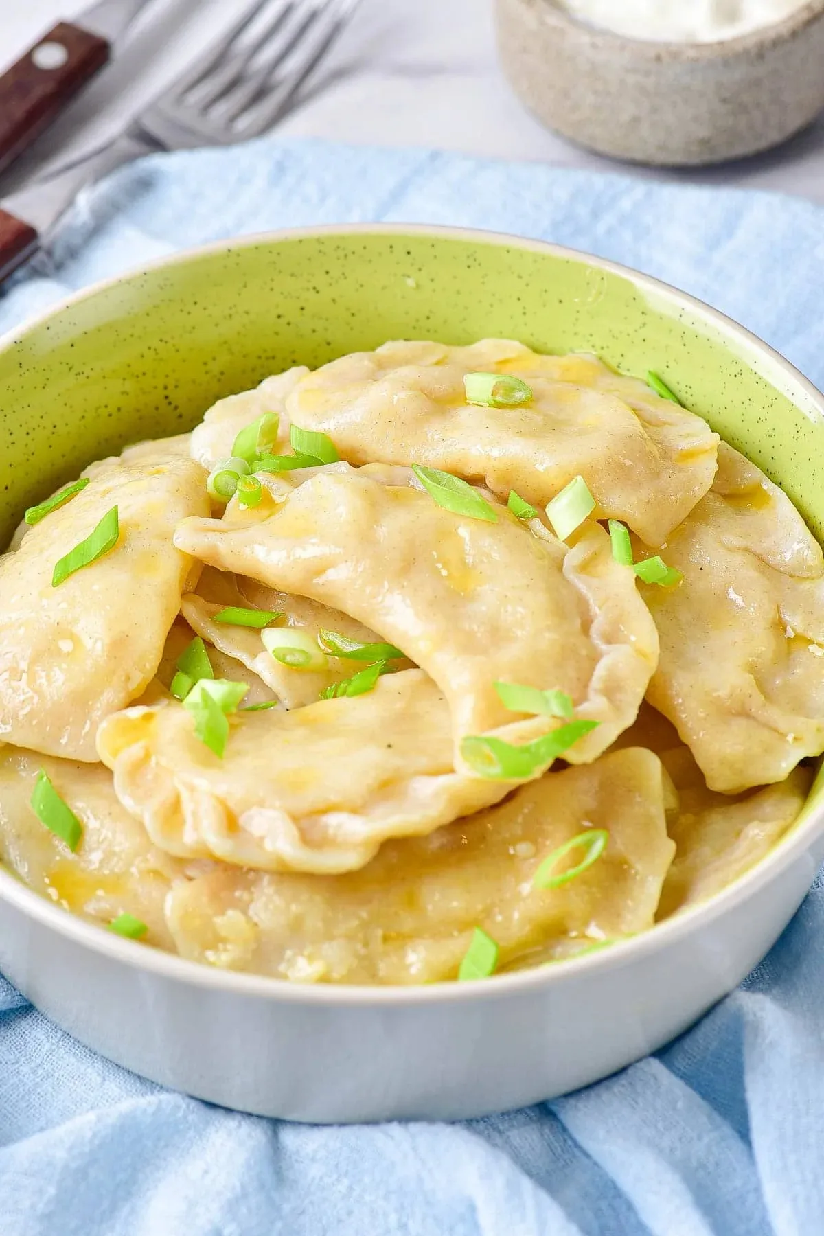 A bowl of varenyky on the blue table cloth | Girl Meets Food