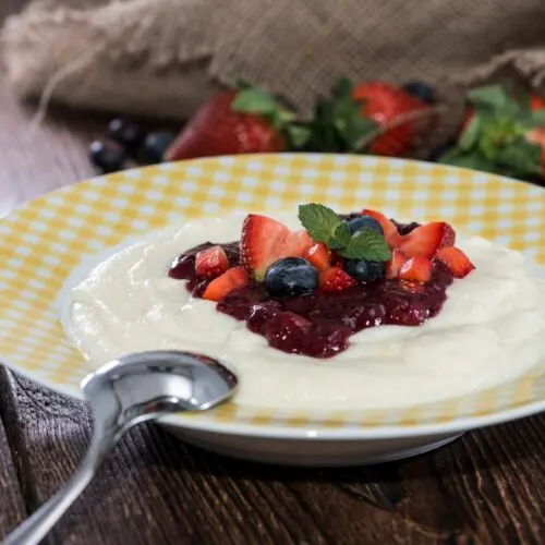 A plate of Buberts topped with berries (Semolina Pudding) on the table | Girl Meets Food