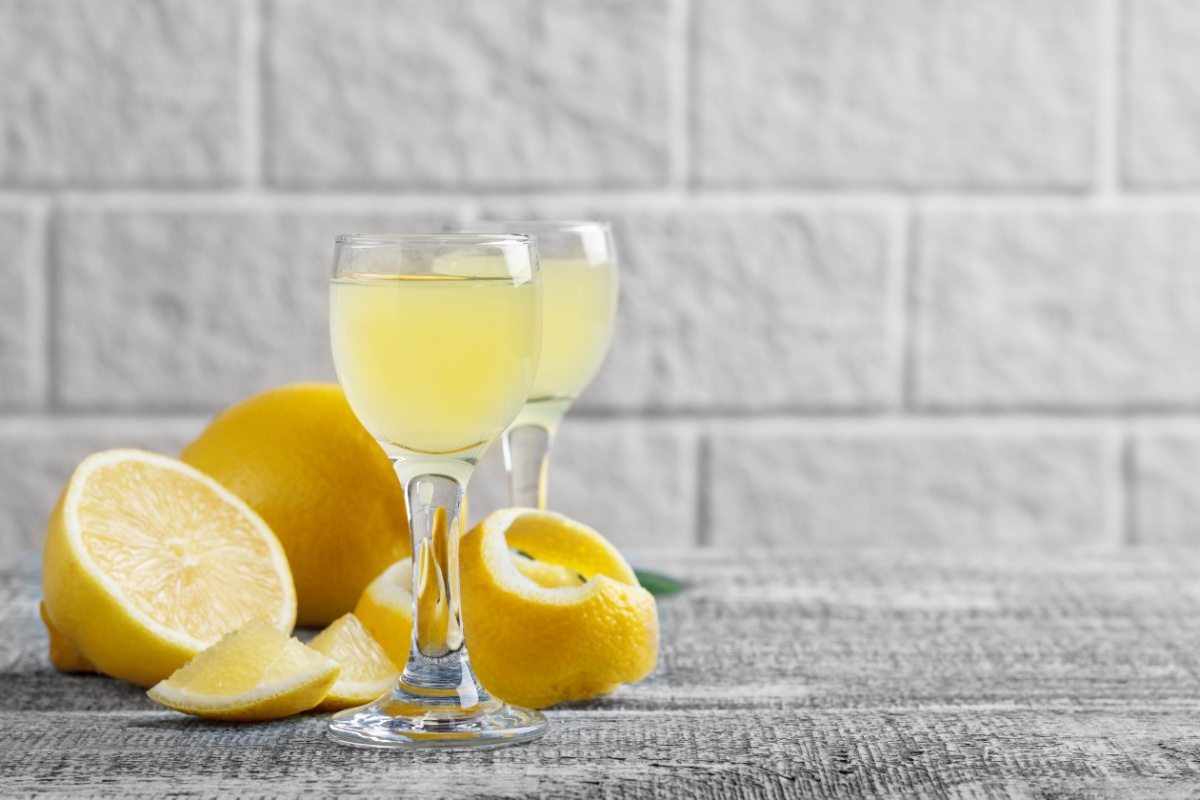 Two shots of Cytrynivka and lemons on a wooden surface | Girl Meets Food