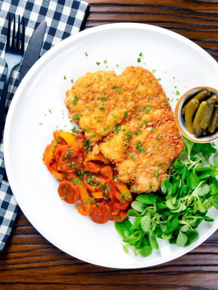 A plate of Kotlet Schabowy with vegetables on the table | Girl Meets Food