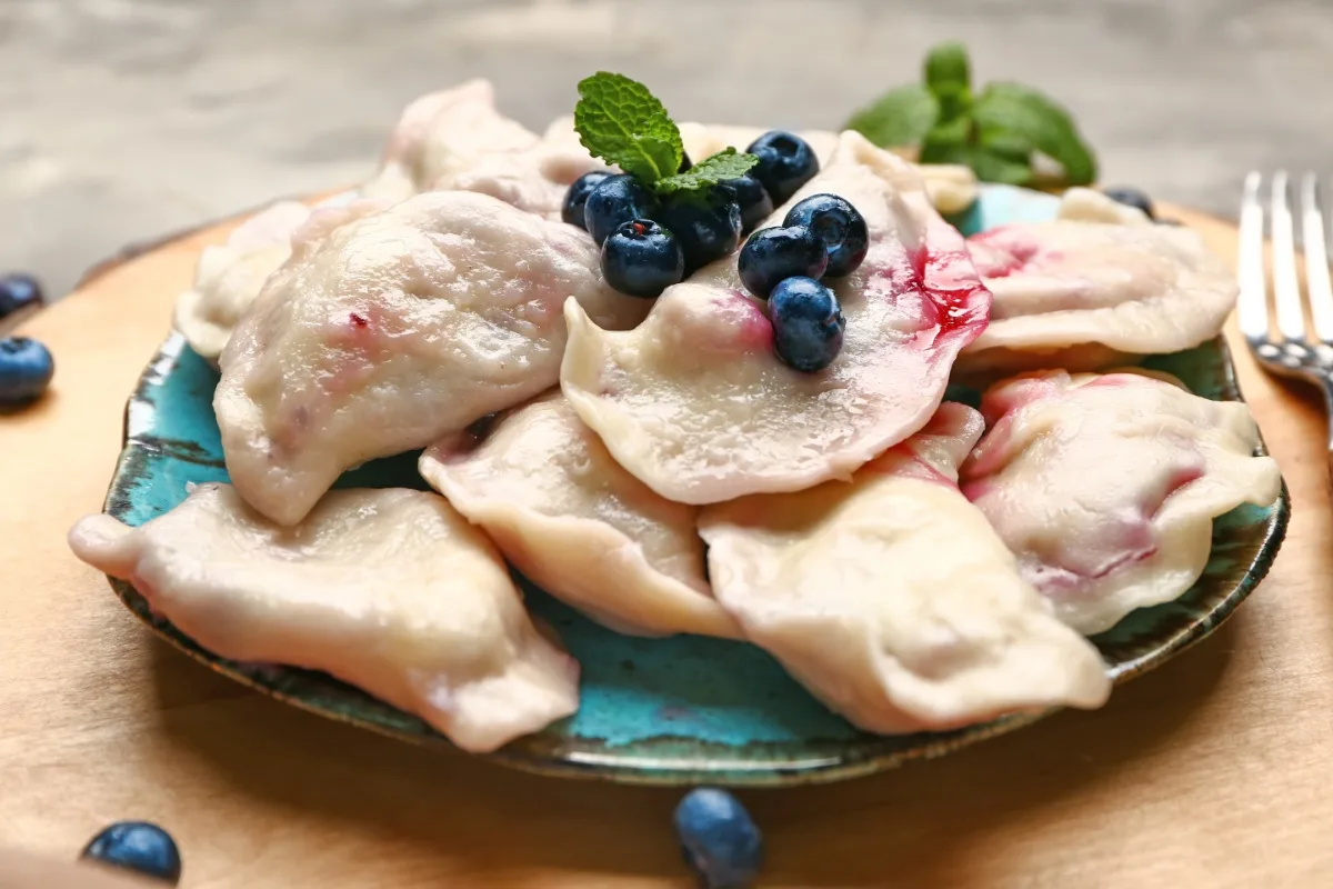 A plate of Melleņu Klimpas (Blueberry Dumplings) on the table | Girl Meets Food