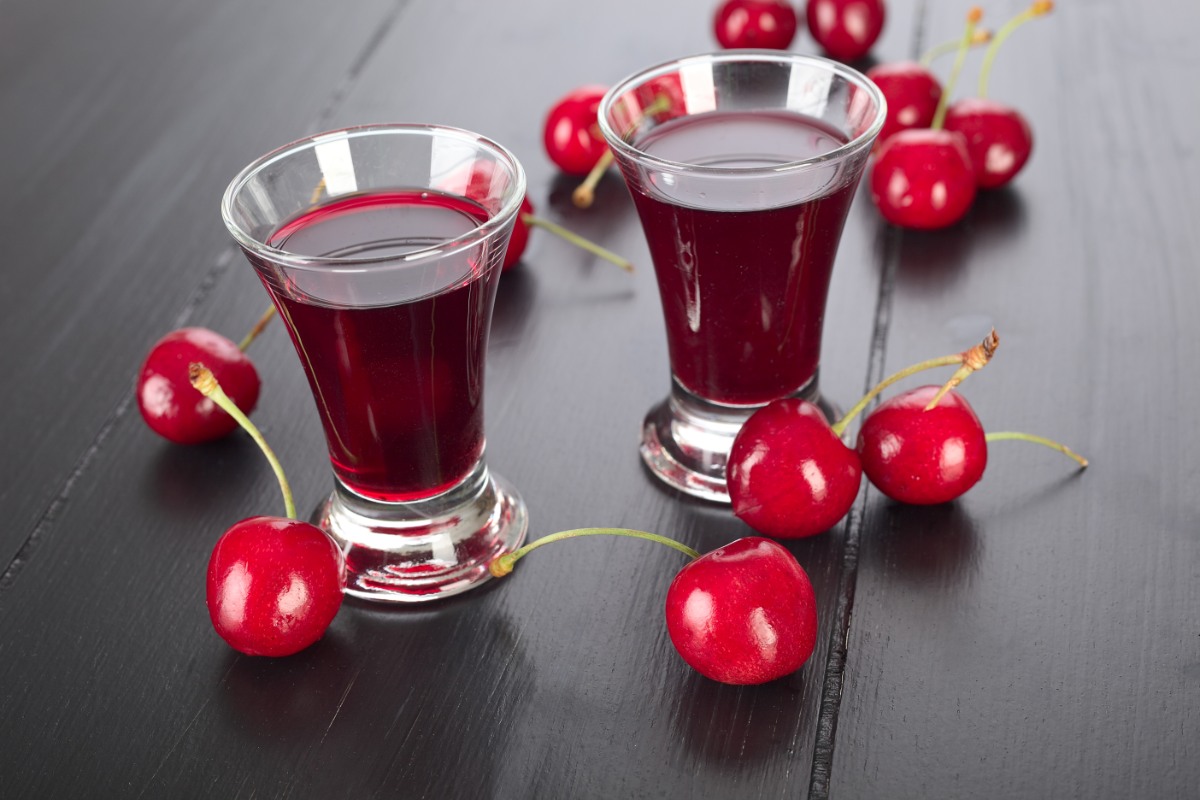 Two shot glasses of piana vyshnia on the table, surrounded with cherries | Girl Meets Food