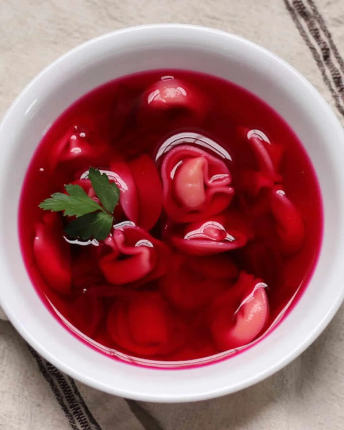 A bowl of Polish Red Borscht on the tablecloth | Girl Meets Food