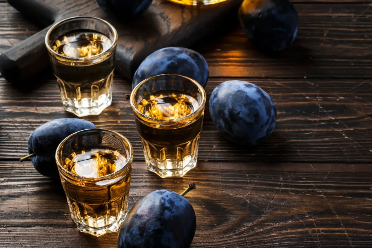 Rakija shots with plums on the table | Girl Meets Food