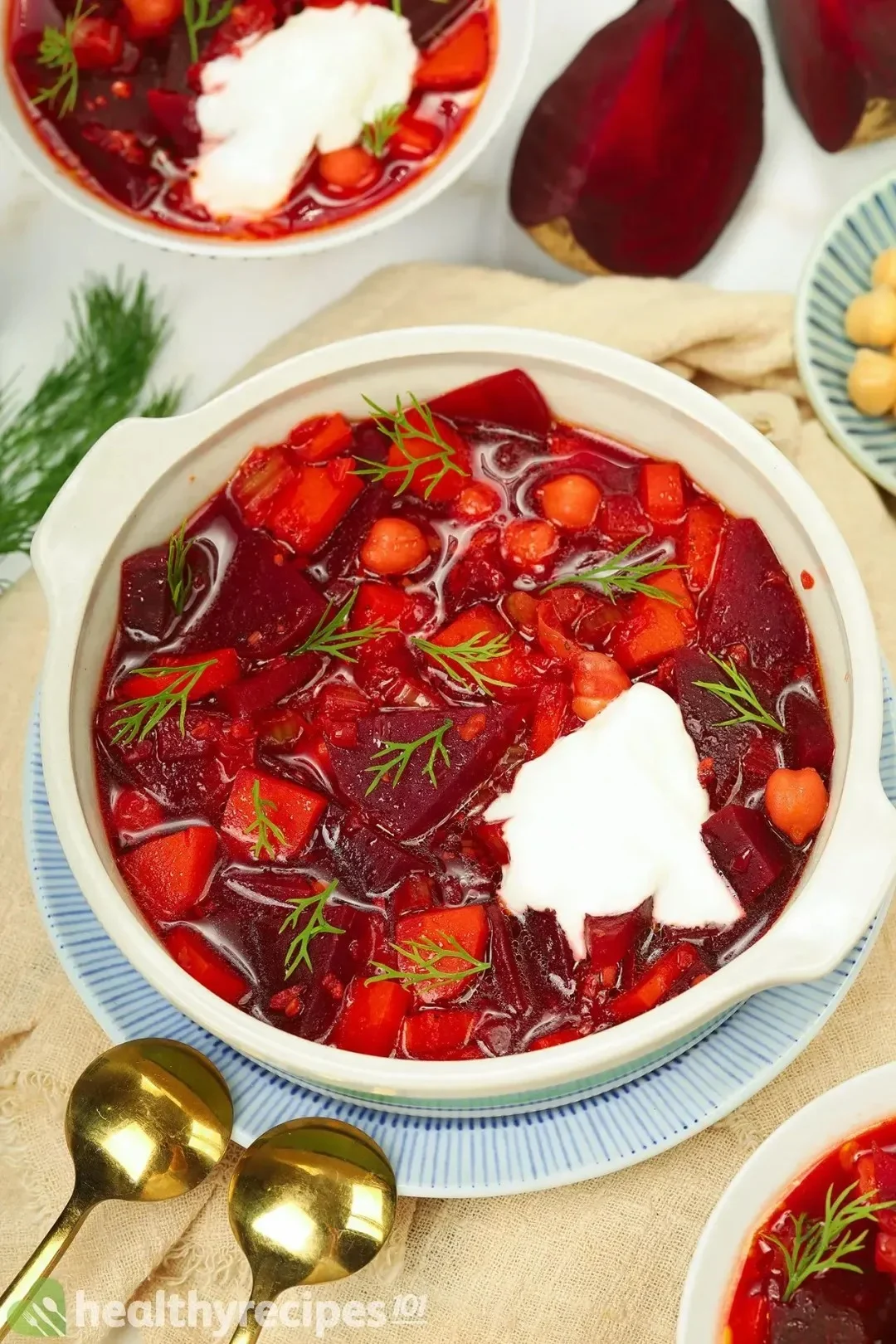 A bowl of borscht soup topped with sour cream on the table | Girl Meets Food