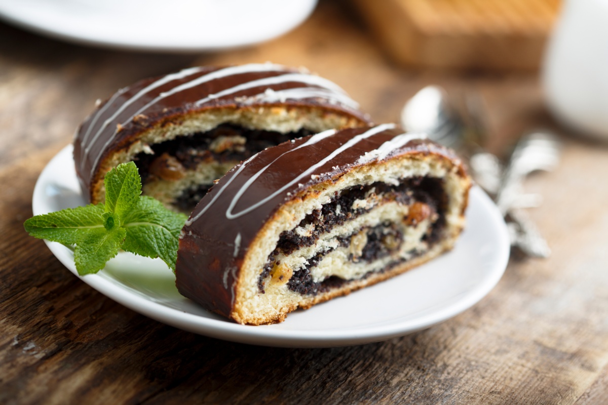 Two slices of Šimtalapis with mint leaves on a plate | Girl Meets Food