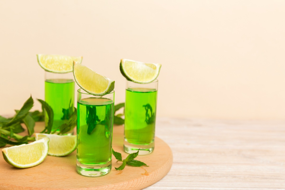 Three shots of menta drink with lime wedges on the cutting boards | Girl Meets Food